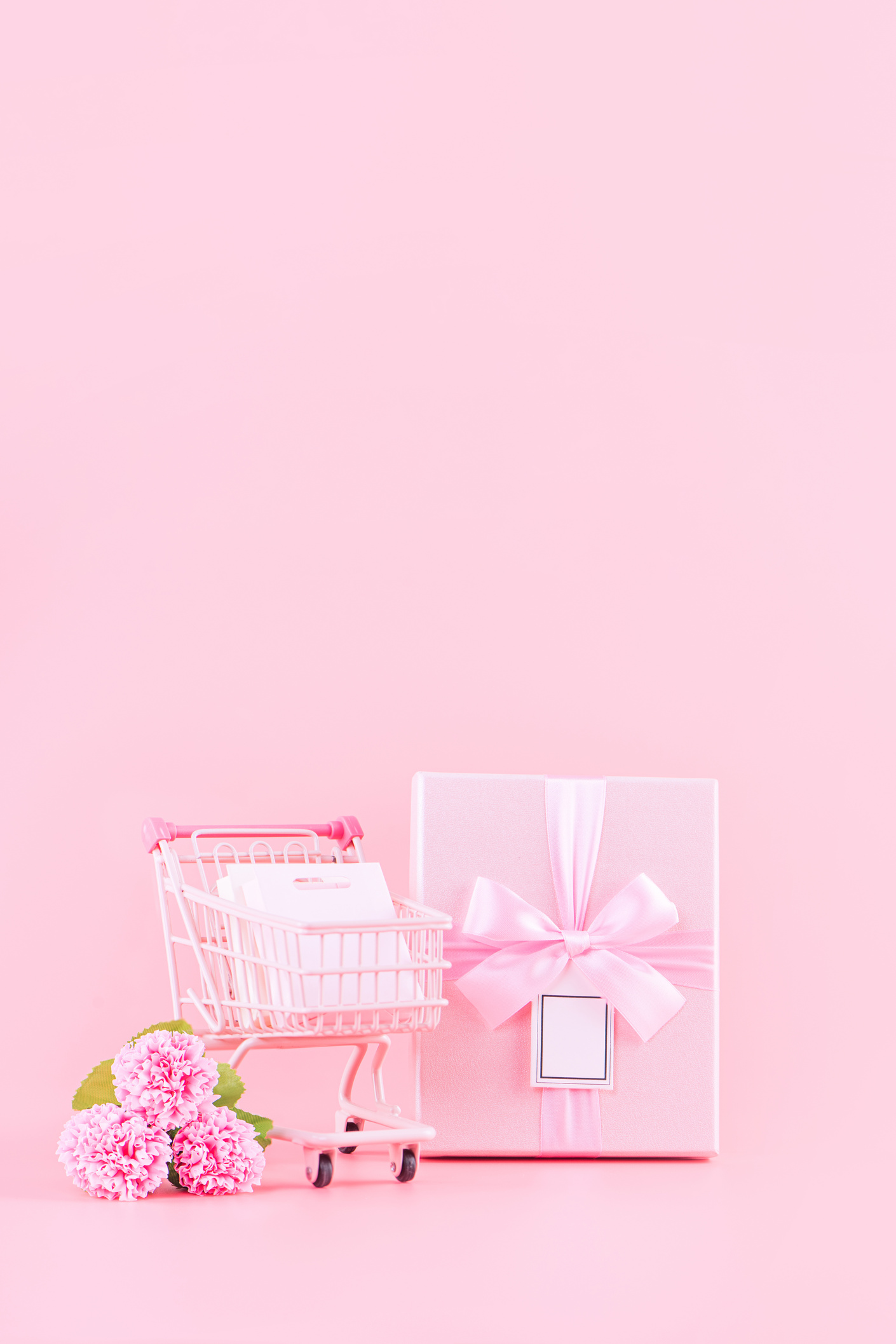 Carnation Flower, Gift Box, and Tiny Cart on Color Background